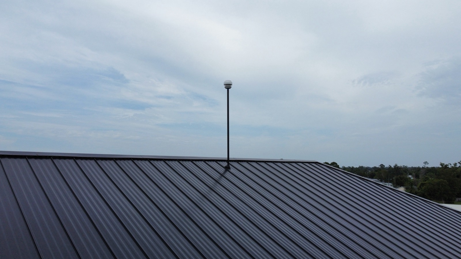 Lightning rod air terminal against the sky on a metal roof ridge